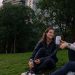 Two women enjoying coffee and conversation in a vibrant park setting in Mexico City.